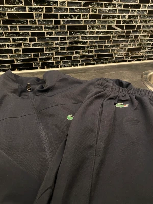 Lacoste tracksuit  - Ganska ny äkta Lacoste tracksuit i mörkblå. Storlek S/M dö den passar båda storlekarna. Trades tas emot (exempelvis Nike tech tracksuits)  samt kan gå ner i pris vid snabb affär