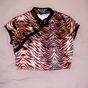 Tigrerad croptop - En croptop i silkes material med korta armar och ett tigrerat mönster, Inte stretchig, I mycket bra kvalité