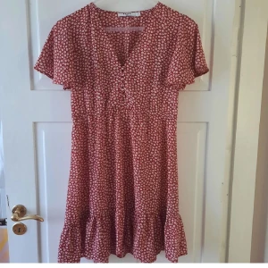 Söt blommig klänning - Jättefin röd och vitblommig klänning från nakd. Strl 40. Sparsamt använd. Skriv privat för fler bilder. 