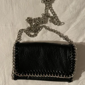 Tiamo väska - En svart tiamo väska i den mindre modellen. Har knappt använt denna så den är i väldigt fint skick. Nypris: 450kr. Säljer för 200kr. Köpare står för frakt. 