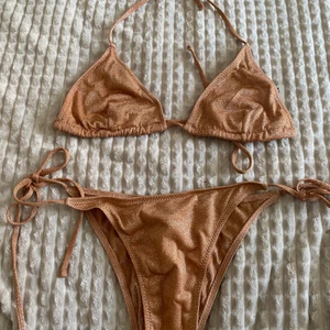 Glittrig bikini  - En glittrig bikini som tyvärr var förliten i brösten för mig. Skulle säga att den passar den med lite mindre/ medel byst. Knytbara band på både trosa och topp så lätt att reglera storlek. 