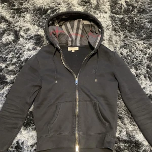 Burberry Zip Hoodie - En limiterad hoodie från burberry som är mycket eftersökt. Kvitto finns.  Säljs pga att den är för lite för mig. Nypris 8200                                  Skick 9-10                          Storlek S                                  Byte är okej. 