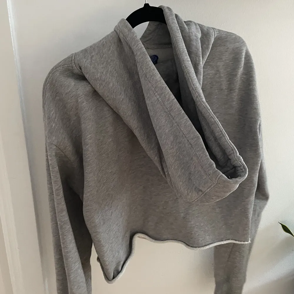 Snygg grå cropped hoodie från Champion med luva. Använd endast vid få tillfällen. Hoodies.