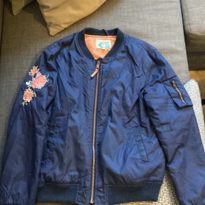 Jacka  - Mörkblå jacka med blommor på höger arm och på ryggen💙