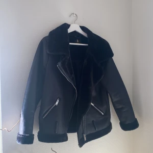 Bikerjacka m mjuk fuskpäls - Mjuuukaste innerfordret, använd fåtal gånger. Lite oversize modell. Har även ett bälte nertill vid midjan som kommer med!