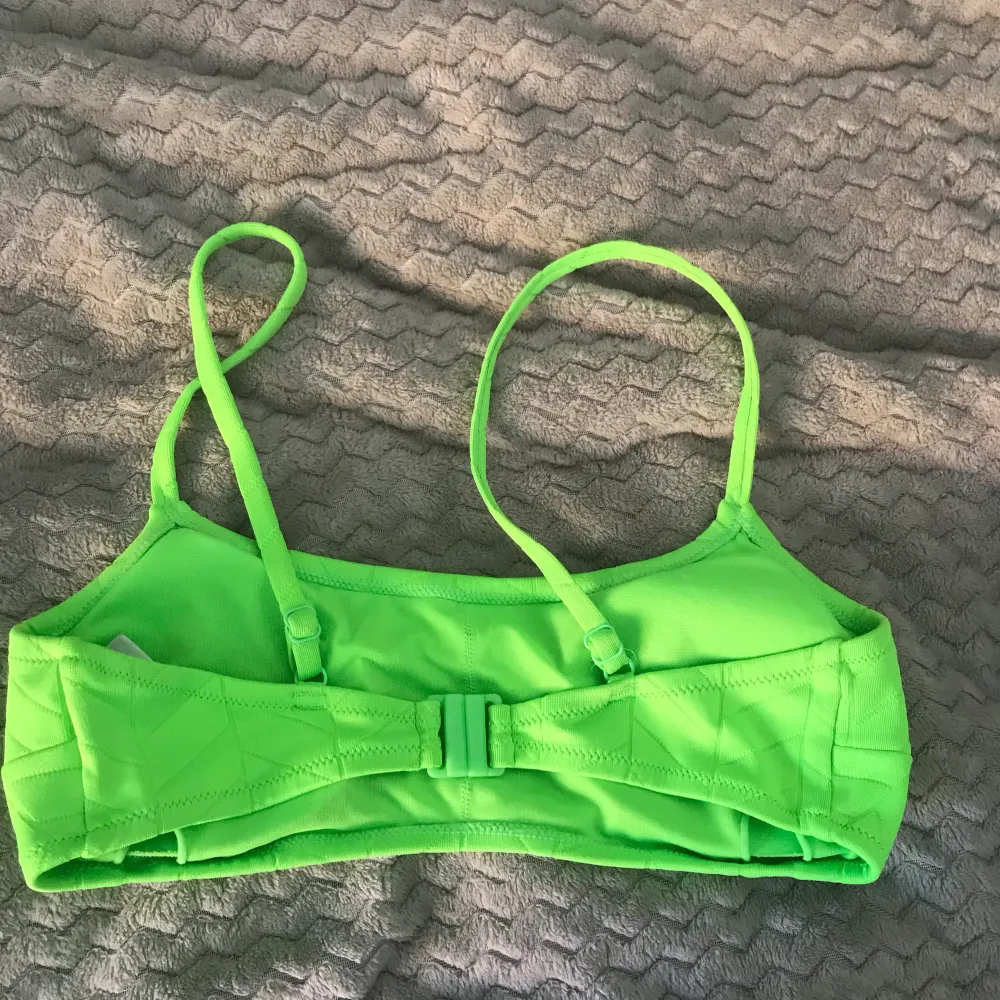 En limegrön bikinitopp som inte kommer till användning längre! Super fin skicka fortfarande! Har knäppe baktill, justerbara axelband och urtagbara pads!😻 . Övrigt.
