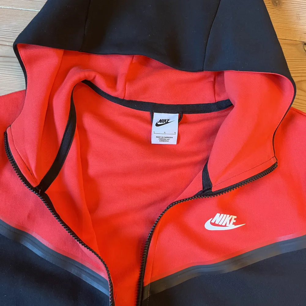 Röt och svart nike tech fleece i storlek L. Kommer aldrig till användning så är som gått som ny i skick! Köpt från Nikes egna sida . Hoodies.