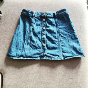 Jeanskjol - Kort jeanskjol med knappar. Lite liten i storleken.