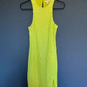 Limegrön paljettklänning med slits - Superfin paljettklänning med mjukt innetyg. Racer-modell. Använd 1 gång 
