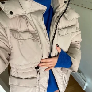 Beige vinterjacka gina - Säljer min beiga vinterjacka från Gina i den perfekta beiga färgen med fickor och dragsko i midjan i storlek M. Jackan är köpt för 2 år sedan men sparsamt använd. Den är nytvättad för bara någon månad sen. Så den är som ny i princip. 