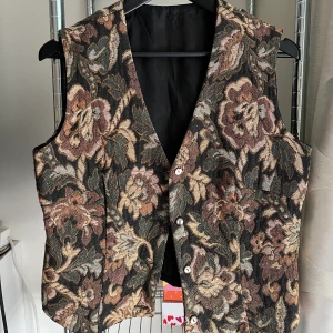 Vintage väst - Snygg bäst som är köpt på Humana! Står ingen storlek men kan passa S-L beroende på önskad passform. Skit snyggt o ha över en vit tisha eller liknande. 🪐