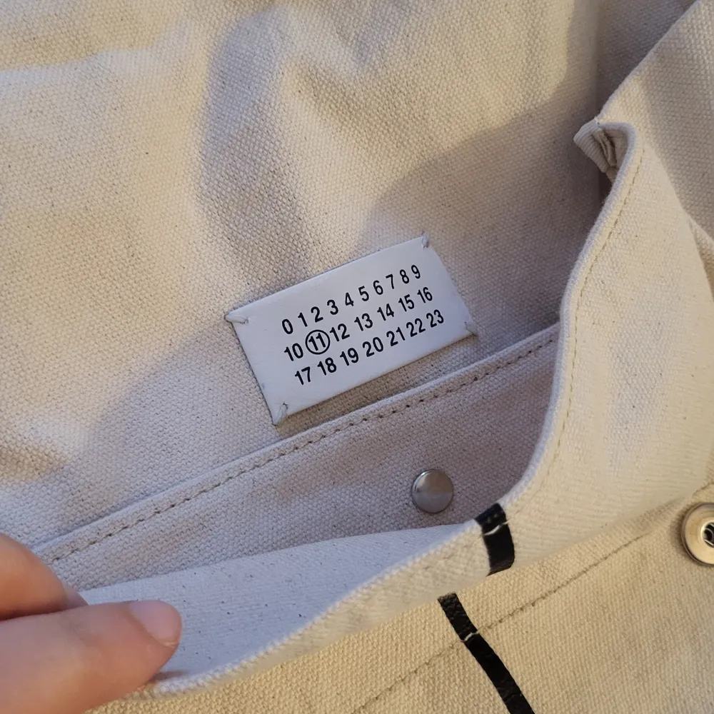 Authentic bag. Maison Martin Margiela backpack in beautiful offwhite canvas with 'Atelier' print. Very good condition, except for one backstrap that is fraying. I'm happy to send additional pics.. Väskor.