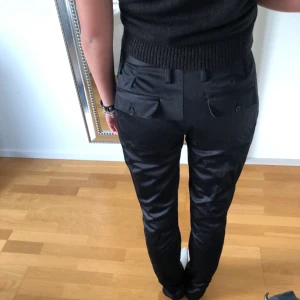 Kostymbyxor med coola fickor - Otroligt snygga byxor från Maads Nørgaard, strl 34 men passar mig bra som brukar ha 36. ”glansiga” i materialet. Väldigt coola fickor. Lite raka i modellen med slits nedtill.  Jag är 170.💗🕺🏽 