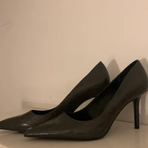 Klackskor - Klackskor från Mango strl 39. Unik design som ser ut som ormskinn aktigt läder. Grå/svart färg.  Använda 1 gång. Nypris-599 kr. Mitt pris 250 kr 😎