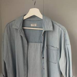 En ljusblå jeansskjorta från Lindex i bra skick, inga defekter. Passar mig som har storlek XS, är lite oversized på mig. Säljer pga att den inte kommit till användning. Jätte fin till en sommarklänning. Köparen står för frakt. 