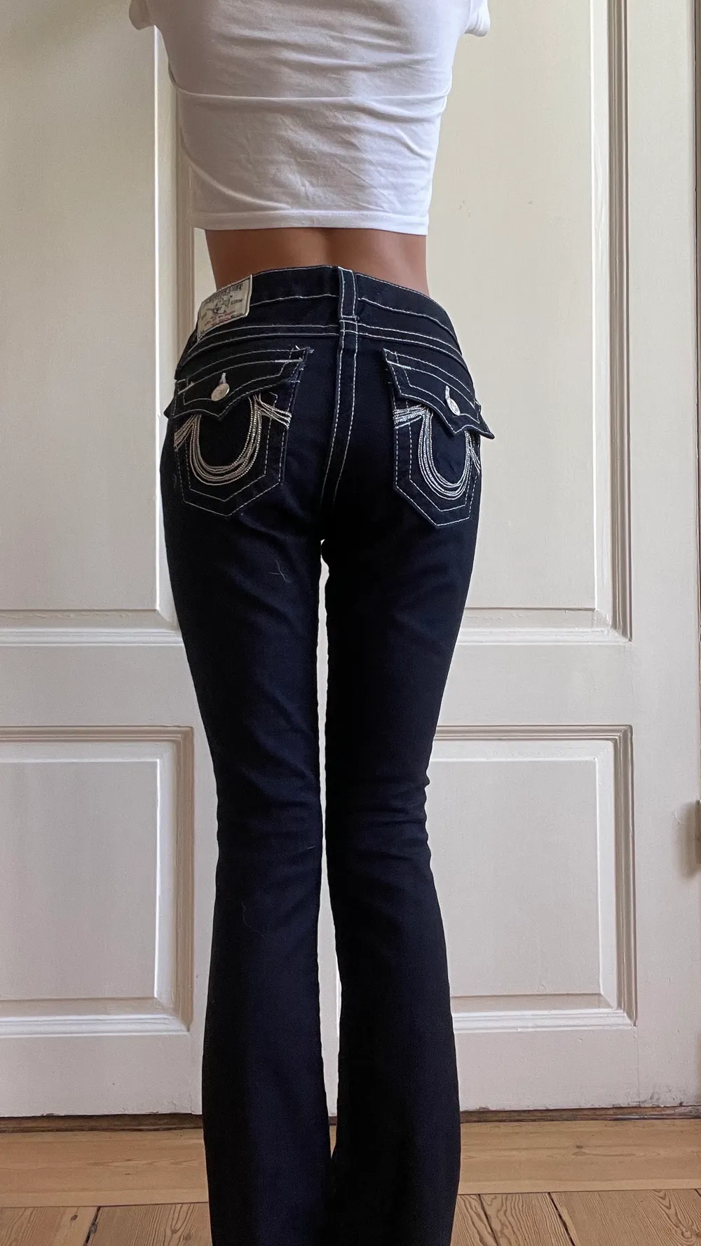 Äkta true religions jeans, väldigt mörk blåa med silvriga nästan vita sömmar.  Fickorna har silver och stenar på fickorna. Jag är 163 cm! Aldrig använda, köpt för 1800kr i london. . Jeans & Byxor.