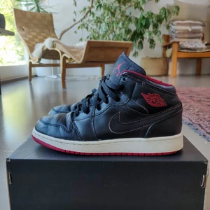 Air Jordan 1 Mid Black/Black/Gym Red - Ett mer sällsynt par Jordan Mids som man inte ser alltför ofta! Använt skick, men mycket liv kvar. Inget slitage förutom lite på sulan.