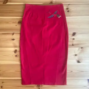 En snygg tajt kjol från märket collectif. 50-tals inspererad design. Röd i färgen med en broderad fågel på. I mycket bra skick, aldrig använt den själv men köpte den secondhand. Möts i Uppsala eller postar! (Sampostar absolut) 🥰