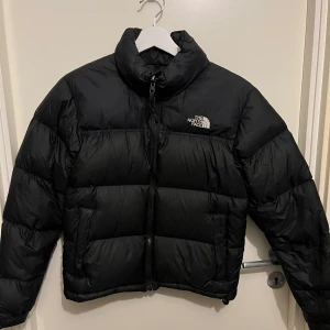 North face 1996 Retro Nuptse Jacket (XS) - Säljer nu min favoritjacka som tyvärr blivit för liten för mig. Den är i väldigt fint skick och riktigt fräsch. Det finns en defekt, ett litet hål som jag även lagt ut bild på. Mormor har sytt hålet, men går nog att sy bättre eller ta till skräddaren. 