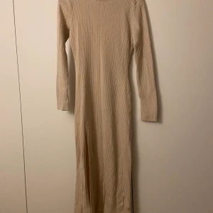 Lång ribbad klänning med slits  - Beige ribbad klänning med slits, passar mig som är en S-M i storleken 