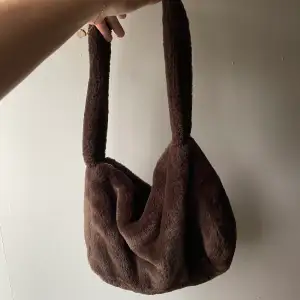 Fluffig brun väska köpt på hm för runt 200kr. Ett stort fack. Inga defekter.
