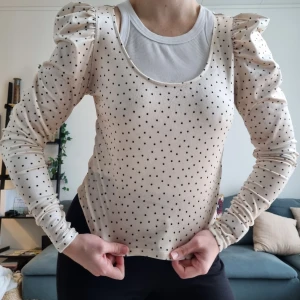 Prickig blus puffiga axlar - Prickig blus/tröja i mjukt material med puffiga axlar. Storlek S. Använd ett fåtal gånger.