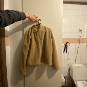 Flis tröja - En beige fliströja från gina tricot som man kan spänna in.  Stl M