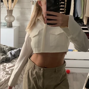 Kort skjorta m öppen rygg - Riktigt snygg kort skjorta med öppen rygg från angelica blicks kollektion med nakd! Storlek 38 , säljs då den inte kommer till användning längre✨
