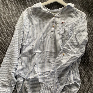 Strandskjorta från Hollister - En vit, blå randig strandskjorta från Hollister. Skriv för fler bilder