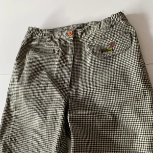 Rutiga byxor - Så fina unika tyg byxor som jag tyvärr växt ur! Lite retro gröntutigt mönster med en fin hund detalj på ena fickan!! Passar någon med storleken xs-s och under 175 cm, annars blir de an aning korta i benen💗