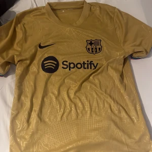 Fotbollströja  - Säljer denna fotbolls tröja från Unisport som jag inte har använt. Barcelonas tredjeställ med Spotify på bröstet