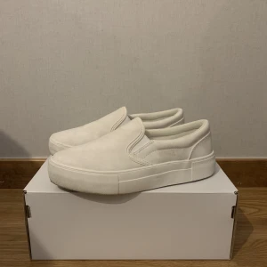 Slip-ins NA-KD - Vita slip-ins från na-kd, storlek 37. Bekväma skor som passar till det mesta. Använt de 2-3 ggr, i fint skick.