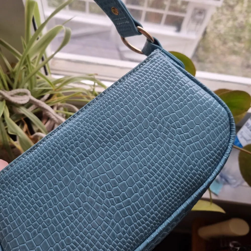 Säljer en jättefin blå liten handväska från asos. Använd 1 gång så som ny. Säljer då den inte kommer till användning. 200kr + frakt💕. Väskor.