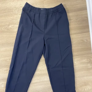 Blå kostymbyxor - Marinblå kostymbyxor från Weekday, länge varit en favorit i garderoben.  Man kan välja att ha slits längs ner eller stänga dragkedjan. Funkar både high och low waist! Nyckelplagg i garderoben som funkar till allt!