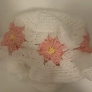 En handgjord virkad mössa med rosa blommor. Som en buckethat. Passar alla och allt🥰