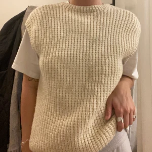 Virkad väst - Simpel virkad/stickad väst, snygg att ha utan tröja under också! Nyskick, säljer då jag sällan använder. Den har ingen storlek men skulle säga att det är en m/l, men det beror ju på hur man vill att den ska sitta.