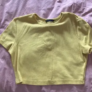 yellow gul crop top baby t shirt. brighter than picture polyester 75%, cotton 25%