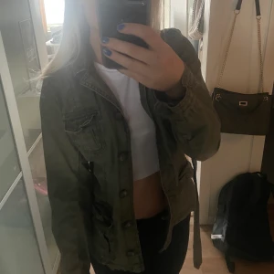 . - En mörkgrön jacka perfekt inför våren och även hösten. I fint skick med fina detaljer. Ett skärp i midjan som man antingen kan knyta eller ta bort. Säljer för 200! Passar mig som har storlek S men passar även en XS skulle jag säga:)