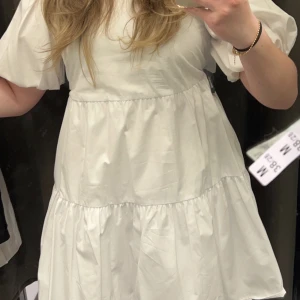 Vit klänning - Säljer denna vita klänning med volanger och öppen rygg, aldrig använd från zara 