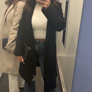 Svart kappa från zara - Säljer denna svarta kappa ifrån zara i storlek ca. Den är så stilren och fräsch och går att klä upp och ner. Köpt för ca 500kr säljer för 250kr