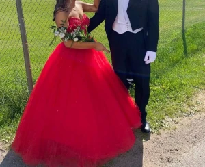 Balklänning - Röd balklänning som passar storlek 32/34 och någon som är 155-160 cm ungefär. Bilderna är från förra ägaren. Dragkedja i ryggen. Underkjol ingår i priset om man vill ha det också.