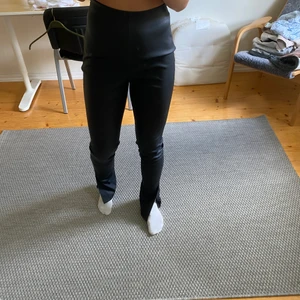Skinnbyxor med slits - Säljer ett par fina skinnbyxor med slits längst ner från NAKD i storlek 34, nästan aldrig använda. Återkommer med fraktkostnad vid intresse