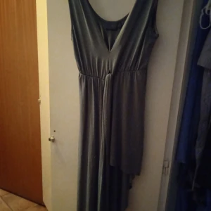 Snygg grön klänning  - Sexig skön klänning i fint skick. Asymmetrisk och så fin urringning både i bak och i fram. Säljer endast pga att jag behöver pengar. Passar en S-M