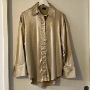 Guldig skjorta från Gina i silk liknande material. Är storlek 34 men är väldigt oversized så bör passar 36, 38 och 40💓