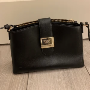 DKNY axelremsväska - Oanvänd väska från DKNY, säljer då den inte kommer till användning. Originalpriset ligger mellan 1500/2000. Pris kan diskuteras vid snabb affär💕