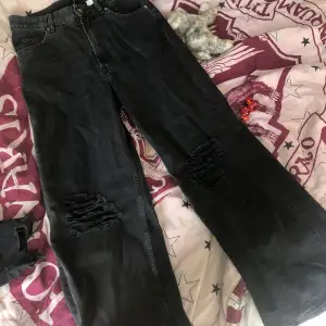 Svarta breda baggy jeans med hål på knäna helt oandvända och passade aldrig mig riktigt den har legat i min garderob i ett år.