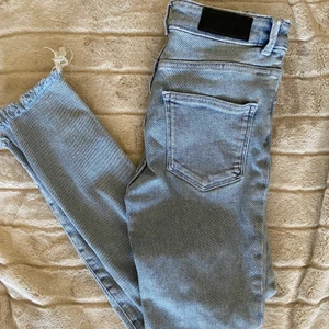 Jeans från bikbok - Jättefina blåa jeans från bikbok lite kortare med slitningar nedtill jättefräscht med sneakers i sommar!! Knappt använda, är dock försmå!
