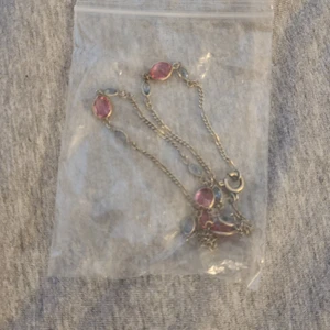 Den kommer från shein - Det är en silvrig kedja och det är blåa och råsa kristaller. Det är en halsband.