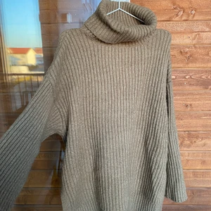 Stickad tröja från Gina  - Snygg brun stickad tröja  från Gina. Kortare framtill och längre baktill. Vida ärmar och hög krage. Passar alla storlekar. Pris kan diskuteras 