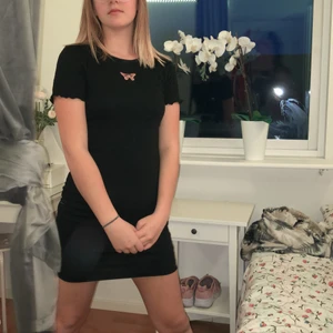 Svart klänning med rosa fjäril från H&M - Svart fin klänning med en rosa fjäril på bröstet. Inte använd. Väldigt fin och gullig 😍 Frakt ingår ej i priset. 